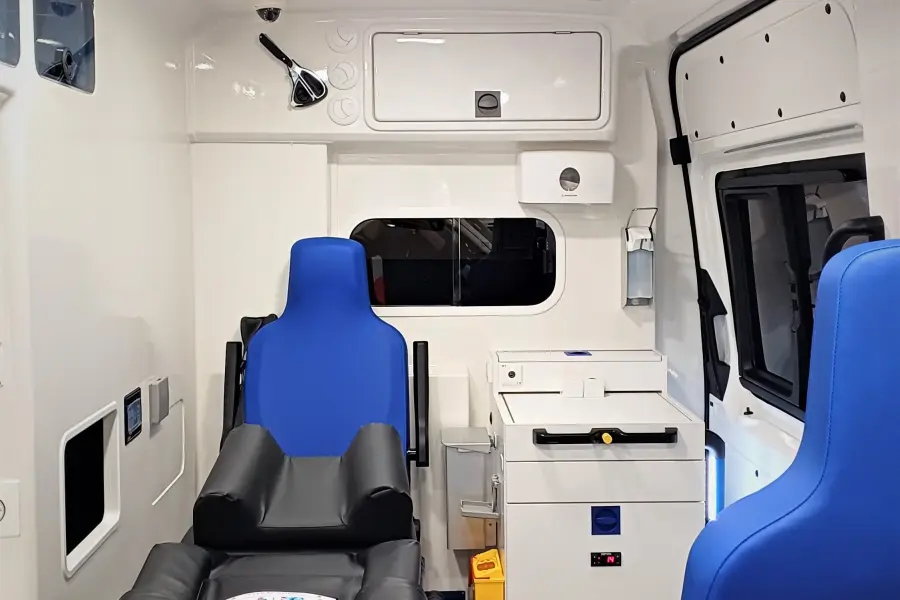 Innenansicht eines modernen Rettungswagens mit Trage, Sitzen und medizinischer Ausstattung.