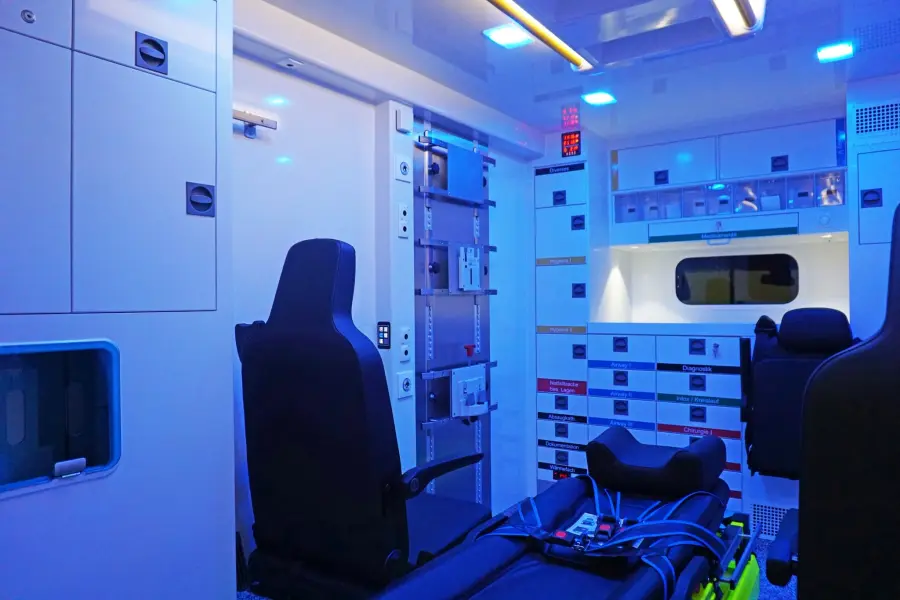 Beleuchteter Innenraum eines Rettungswagens mit blauer Ambientebeleuchtung und klar strukturierter Ausstattung.