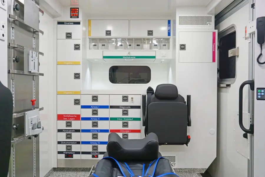 Innenansicht eines Rettungswagens mit klar strukturierter, farbcodierter Stauraumorganisation und moderner Ausstattung.