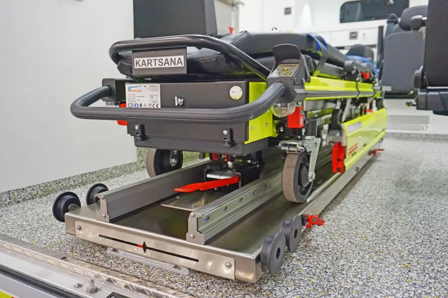 Nahaufnahme einer Kartsana-Trage auf Schienensystem im Rettungswagen.