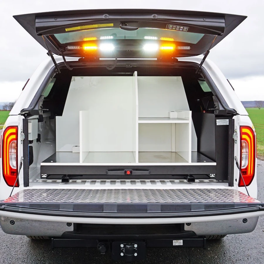 Heckansicht eines Einsatzleitfahrzeugs mit geöffnetem Laderaum und ausgebautem Ordnungssystem.